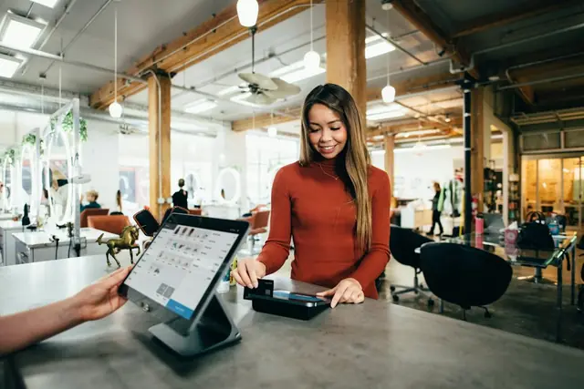 Kasir toko melayani pembayaran di terminal POS
